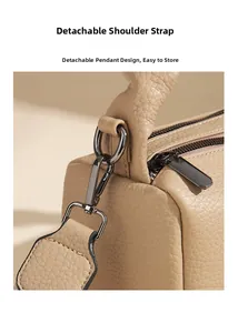 Detail of lychee pattern leather handbag with dark nickel hardware and removable strap