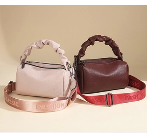 Detail of pink and brown leather boston bags with cloud-shaped handles and woven straps