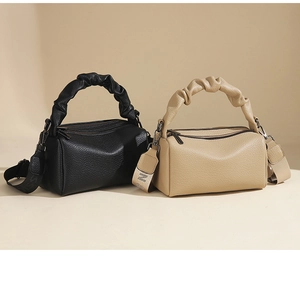 Detail of lychee pattern leather handbag with ruched handle and dual zipper design