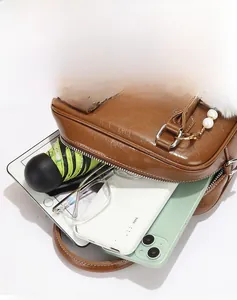 Top view of brown leather crossbody bag showing high capacity for tablets and daily essentials