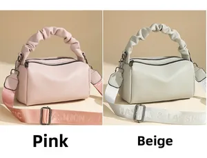 Detail of pink and beige lychee leather pillow bags with pleated handles and wide straps