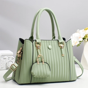 Mint green pleated tote bag with golden hardware and matching coin purse on grey background