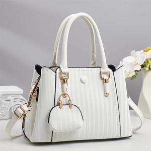 Detail of white pleated tote bag with golden hardware and matching mini charm pouch
