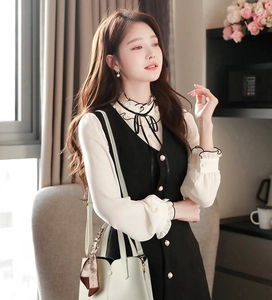 Close-up of elegant V-neck vest dress paired with white chiffon shirt and mint green handbag