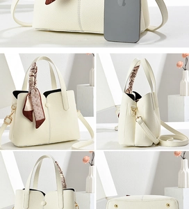 Detail view of white textured leather crossbody bag with decorative silk scarf and gold hardware