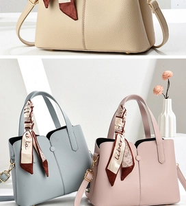 Detailed view of elegant lychee leather texture and decorative silk scarves on handbags