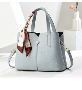 Detail of light blue pebble leather bag with scarf wrap and metallic hardware