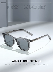 Detailansicht der grauen Sonnenbrille mit Silbernieten auf minimalistischem Geometrie-Sockel