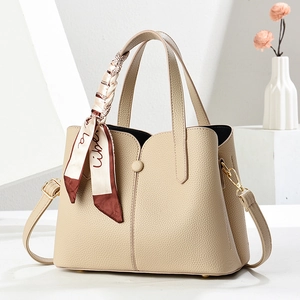 Elegant beige lychee grain leather handbag with decorative silk scarf and shoulder strap