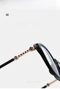 Close-up of black frames with rose gold metal temples and floral hinge details