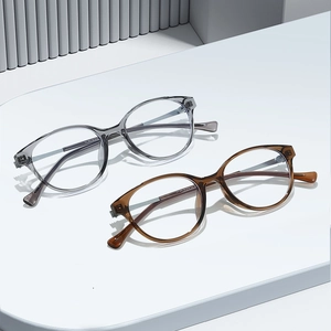 Chic round anti-blue light glasses in transparent grey and tea colors on a display