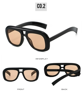 Three-angle display of oversized double-bridge sunglasses with amber lenses and black frames