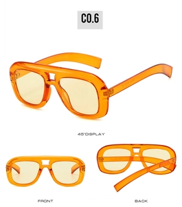 Detail view of orange oversized sunglasses with double bridge and transparent resin frame