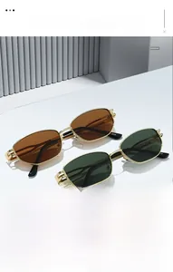 Détail de montures métalliques dorées sur lunettes géométriques avec charnière ajourée