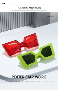 Detail view of modern oversized geometric sunglasses in red and green on display
