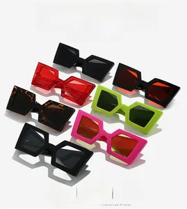 Flat lay of oversized geometric square sunglasses in various vibrant colors on white backdrop
