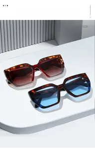 Detailed view of oversized tortoise shell sunglasses with gradient lenses on a display