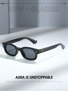 Detail view of black square vintage sunglasses with gold rivet accents on grey background