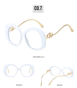 Detail view of white wavy glasses frame with golden heart-shaped metal temples