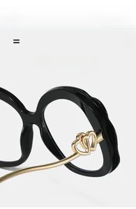 Detail of golden heart hinge on black frame blue light glasses with wave texture