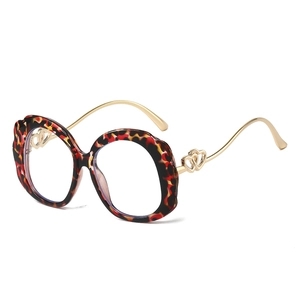 Fashionable oversized round leopard print glasses with golden heart metal legs on white background