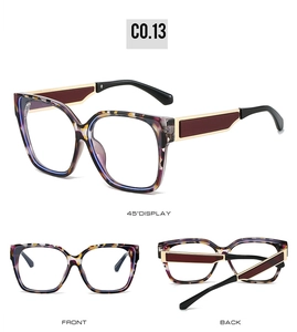 Macro display of square cat-eye eyewear with purple yellow tortoiseshell pattern and gold arms