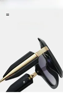 Detail of premium sunglasses featuring golden metal hinges and high-quality black frame