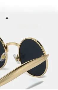 Détail des charnières élastiques légères et de la monture ovale dorée de lunettes rétro