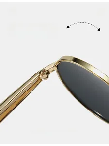 Détail macro des charnières en métal doré sur des lunettes de soleil ovales