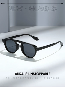 Detail einer schwarzen runden Sonnenbrille mit flachem Steg und Silbernieten-Akzenten