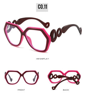 Detail of geometric oversized sunglasses featuring dual-tone red frames and wavy temples