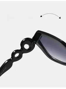 Detail view of black wide-frame sunglasses showing wavy hollow-out temple design