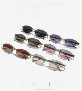 Close-up of rimless oval sunglasses showing gold metal temples and spiral textured hinges