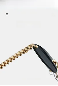 Macro view of gold metal temples with pyramid rivets on rimless cat eye sunglasses
