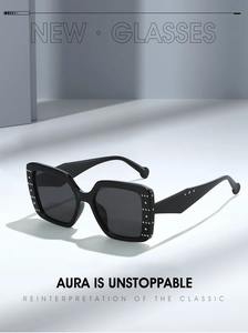 Close-up of black square sunglasses featuring silver rivet studs on the frame