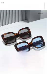 Close-up of tortoise square sunglasses featuring silver rivet details and colored lenses