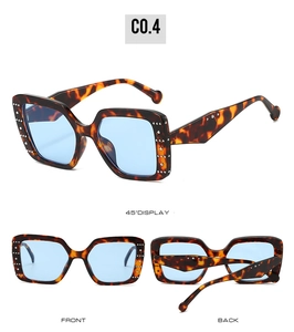 Detail view of square tortoiseshell sunglasses with blue lenses and silver metal studs