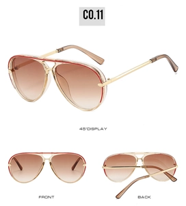 Detail view of gold aviator sunglasses with brown gradient lenses and red stripe accents
