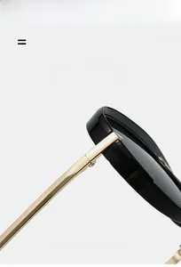 Detail view of glossy black oversized frame sunglasses with golden metal temples