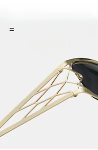 Detail of lightweight golden Y2K sunglasses with hollow geometric temples and tiny crystal