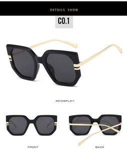 Detail of oversized square sunglasses with black frames and gold metal temples