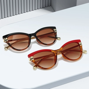 Vintage cat-eye sunglasses with gradient lenses and metal temples on a white geometric stand