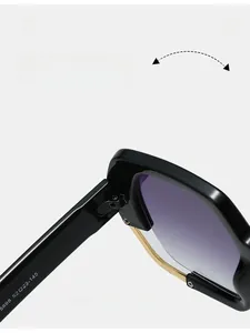 Detail of black frame sunglasses showing gold metal hinges and gradient purple lenses
