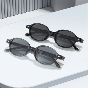Modern oval TR90 sunglasses in black and transparent grey with silver diamond accents