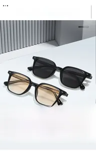 Détail de lunettes de soleil carrées en TR90 avec rivets et verres teintés sur un support