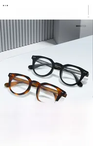 Detail view of TR90 round frame glasses showing hinge specs TR28051 on modern white stand