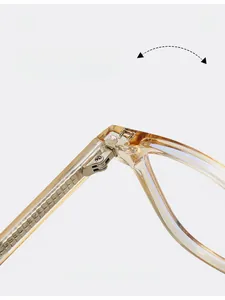 Détail macro de la charnière en métal sur une monture de lunettes TR90 ambre clair