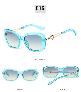 Detail view of butterfly sunglasses with blue frame, gold metal temples and gradient lens