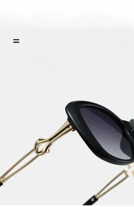 Detail of lightweight golden metal temple hinge on premium black resin sunglasses