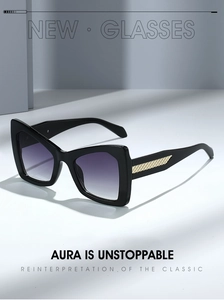 Detail of black cat-eye sunglasses with gold woven metal accents and gradient purple lenses